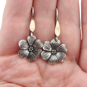 Elegant flower-shaped dangle earrings crafted from sterling silver and solid 9K yellow gold, featuring sparkling white CZ stones. These timeless earrings combine sophistication and nature-inspired beauty, perfect for everyday wear or special occasions