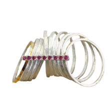 Load image into Gallery viewer, A bold and unique wide ring featuring two 9k solid yellow gold bands and eight 1mm solid sterling silver matte-textured rings. The design is accentuated by a vertical sterling silver bar adorned with sparkling ruby stones, creating a striking and elegant statement piece.
