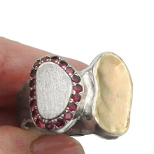 Load image into Gallery viewer, A handcrafted sterling silver and 9k yellow gold ring featuring a brushed silver surface, a polished gold accent, and a stunning border of sparkling natural ruby stones. This elegant and artistic design is a unique statement piece for any jewelry collection