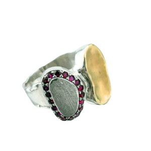 A handcrafted sterling silver and 9k yellow gold ring featuring a brushed silver surface, a polished gold accent, and a stunning border of sparkling natural ruby stones. This elegant and artistic design is a unique statement piece for any jewelry collection